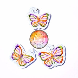 May include: Three embroidered butterfly keychains with pink, orange, and green accents. The keychains are on a white background with a logo that says "Lisey Digital Designs".