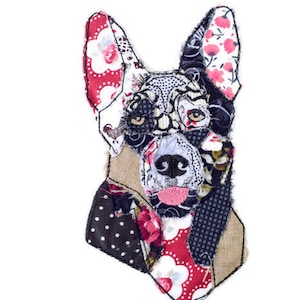 Könnte beinhalten: Ein Patchwork-Hundeportrait aus schwarzem, weißem, rotem und rosafarbenem Stoff. Das Gesicht des Hundes ist detailliert gestickt und der Stoff ist zu einem einzigartigen und farbenfrohen Design zusammengenäht.