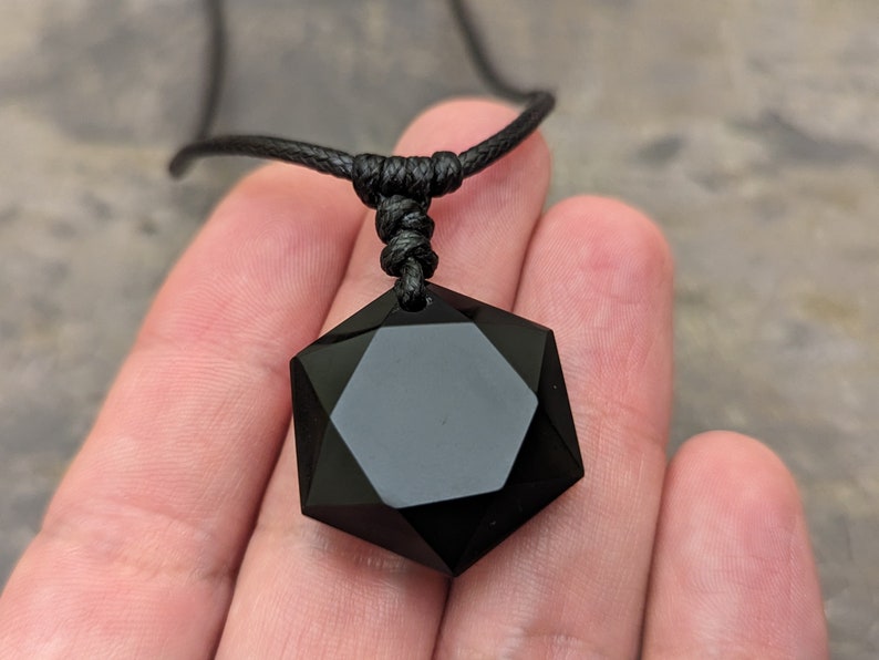 May include: Black obsidian star of David pendant necklace on a black cord.