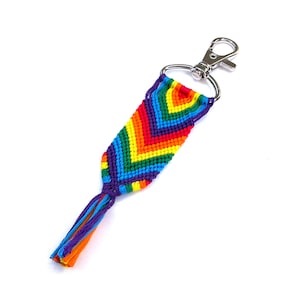 Può includere: Portachiavi con braccialetto dell'amicizia arcobaleno con un anello portachiavi argentato e un pon pon.