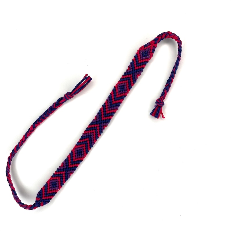 May include: A red and blue friendship bracelet with a diamond pattern.