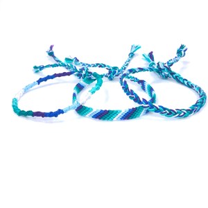 Puede incluir: Tres pulseras de la amistad en colores azul, verde y blanco. Las pulseras est&aacute;n tejidas con un patr&oacute;n simple y tienen un cierre anudado.