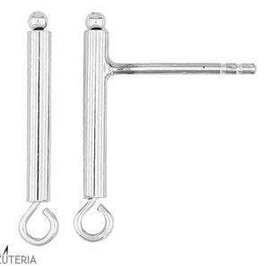 Pode incluir: Um par de brincos de prata. Cada brinco apresenta um poste vertical com ranhuras, com uma pequena bola no topo e uma argola na parte inferior. Um brinco tem um poste horizontal para a orelha. Fundo branco.