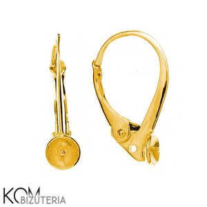 Peut inclure: Deux apprêts de boucles d'oreilles à levier de couleur or. Les apprêts ont une base ronde avec un petit trou et un levier articulé qui fixe la boucle d'oreille. Les boucles d'oreilles sont conçues pour être attachées à un pendentif ou à un charme.