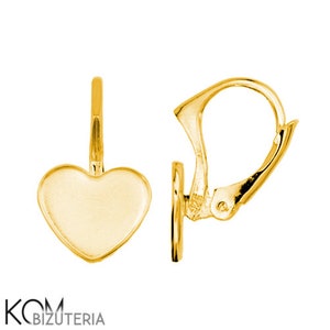 Peut inclure: Une paire de boucles d'oreilles dorées en forme de cœur. Chaque boucle d'oreille est dotée d'un fermoir à levier et d'un pendentif en forme de cœur lisse et poli. Les boucles d'oreilles sont présentées sur fond blanc, mettant en valeur leur surface brillante et réfléchissante.
