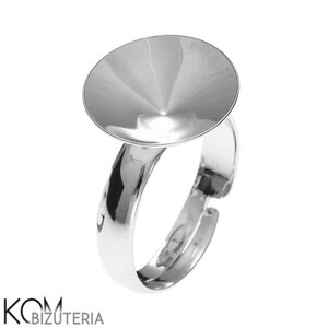 Peut inclure: Une bague argentée brillante avec un grand sertissage circulaire. L'anneau est réglable et a une finition lisse et polie. Le sertissage est en forme de cône inversé peu profond. La bague est conçue pour la création de bijoux.