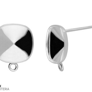 Pode incluir: Dois brincos de botão quadrados prateados com um design geométrico. Cada brinco apresenta um pino para perfurar e um pequeno laço na base. Os brincos têm uma superfície refletora com um padrão preto, branco e cinza.