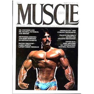 Può includere: Un uomo muscoloso posa per un servizio fotografico. Indossa pantaloncini da bagno blu e ha un'espressione seria sul viso. La foto è tratta da una rivista chiamata "Muscle" e presenta articoli sul bodybuilding e sul fitness.