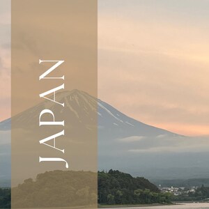 May include: A travel guide cover featuring a scenic view of Japan, with Mount Fuji in the background. The word "JAPAN" is vertically stacked in white letters. The words "TRAVEL GUIDE" are at the bottom.