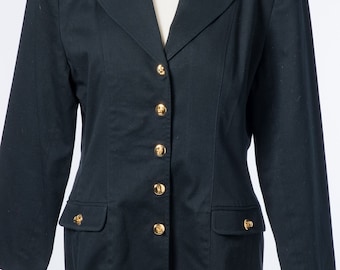 Könnte beinhalten: Ein marineblauer Blazer mit goldenen Knöpfen und Taschen. Der Blazer hat ein klassisches, maßgeschneidertes Design mit einem Reverskragen und langen Ärmeln. Die goldenen Knöpfe verleihen dem Kleidungsstück einen Hauch von Eleganz.