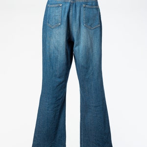 May include: A pair of blue denim jeans with a straight leg fit. The jeans have a classic five-pocket design and a button fly.