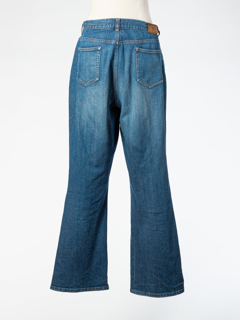 May include: A pair of blue denim jeans with a straight leg fit. The jeans have a classic five-pocket design and a button fly.
