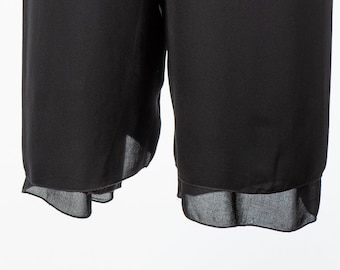 May include: Black pants with a sheer, ruffled hem.