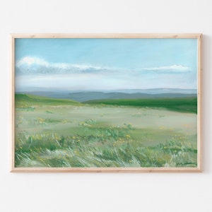 May include: A framed painting of a green grassy field with a blue sky and white clouds in the background.