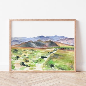May include: Watercolor painting of a landscape with a winding path leading through a field of green grass towards a mountain range in the distance. The mountains are painted in shades of blue, purple, and brown.