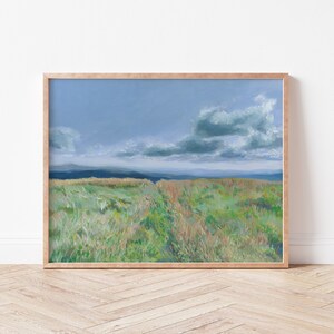 May include: A framed painting of a landscape with a field of green grass and a blue sky with white clouds. The painting is in a wooden frame.