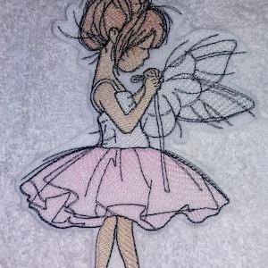 May include: Embroidered patch of a ballerina with brown hair, wearing a pink tutu and holding a wand. She has a white butterfly wing on her back.