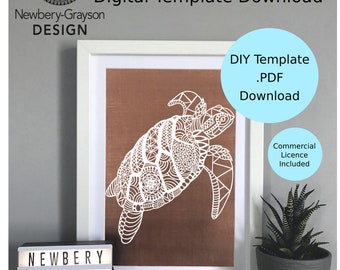 May include: A white paper cut-out of a turtle with intricate mandala designs on its shell and body. The turtle is framed and displayed on a shelf with a small light-up sign that reads "Newbery Grayson Design".