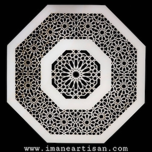 May include: White octagonal decorative wall panel with a black intricate geometric pattern. The pattern features a central starburst design surrounded by smaller repeating geometric shapes.