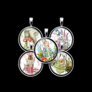May include: Five round silver pendants featuring illustrations of storybook characters. The pendants showcase a squirrel, a rabbit with carrots, a duck, a mouse reading, and a frog on a lily pad, all set against a black background.
