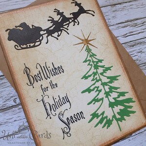 Handgemaakte kerstkaart, kerstslee met rendieren en kerstboom