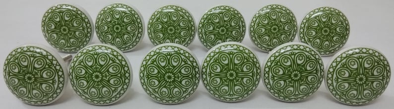 May include: Twelve ceramic knobs in green and white with a decorative floral pattern.