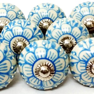 Peut inclure: Ensemble de boutons de meubles en c&eacute;ramique avec un motif floral bleu et cr&egrave;me. Chaque bouton a une base m&eacute;tallique argent&eacute;e. Les boutons sont ronds et d&eacute;coratifs, adapt&eacute;s &agrave; divers meubles. Le design est sym&eacute;trique.
