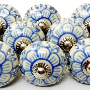 Peut inclure: Ensemble de dix boutons de meubles en c&eacute;ramique. Chaque bouton est rond, avec une base cr&egrave;me et un motif floral bleu. Les boutons ont une base et une vis en m&eacute;tal argent&eacute;. Ces boutons d&eacute;coratifs sont parfaits pour ajouter une touche d'&eacute;l&eacute;gance aux meubles.