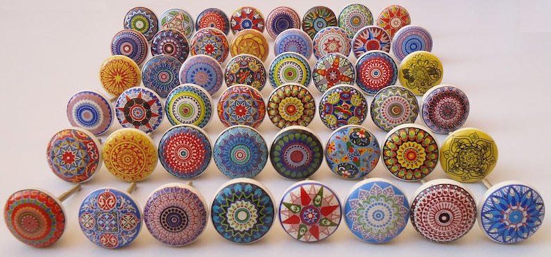 May include: A collection of 36 colourful ceramic drawer knobs with intricate mandala designs. Each knob features a unique pattern in shades of blue, red, yellow, green, and white.