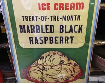 Può includere: Un poster vintage che pubblicizza il gelato Broadview con il testo "Treat-of-the-Month: Marbled Black Raspberry". Il poster presenta un primo piano di una pallina di gelato con vortici di lampone nero.