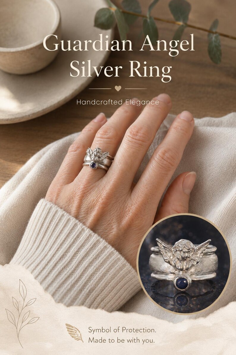 May include: A silver ring featuring a sculpted angel figure with wings spread wide and a small, round, dark blue gemstone set into the band. The text Guardian Angel Silver Ring, Handcrafted Elegance, and Symbol of Protection. Made to be with you. is visible.