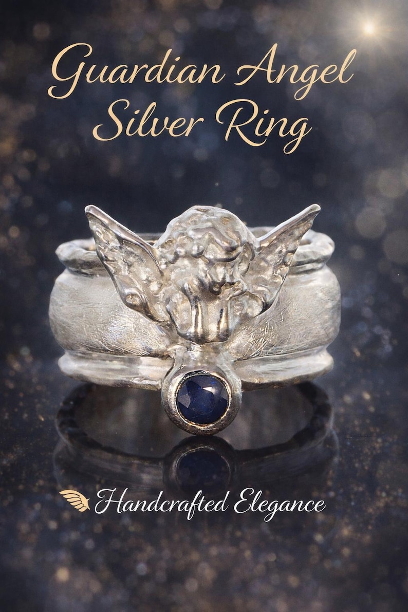May include: A silver ring featuring a sculpted angel with outstretched wings and a small, round, dark blue gemstone set at the base. The text "Guardian Angel Silver Ring" and "Handcrafted Elegance" with a small wing icon appear in the image.
