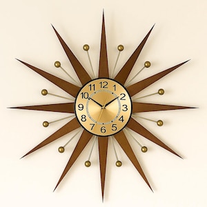 May include: A mid-century modern starburst clock with a gold-tone face and black numerals. The clock features brown wooden rays and gold-colored accents. The clock's diameter is approximately 24 inches.