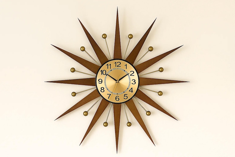 May include: A mid-century modern starburst clock with a gold-tone face and black numerals. The clock features brown wooden rays and gold-colored accents. The clock's diameter is approximately 24 inches.