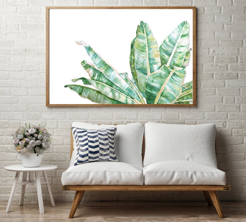 Op de afbeelding: Een ingelijst aquarel schilderij van groene bananenbladeren op een witte achtergrond. De bladeren zijn in een waaier vorm gerangschikt en hebben een realistische, gedetailleerde textuur.
