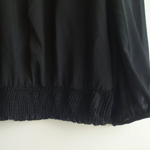 May include: Black sheer top with a gathered elastic band at the bottom.