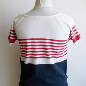 K&ouml;nnte beinhalten: Ein wei&szlig;-marineblaues, kurz&auml;rmeliges Shirt mit roten Streifen.