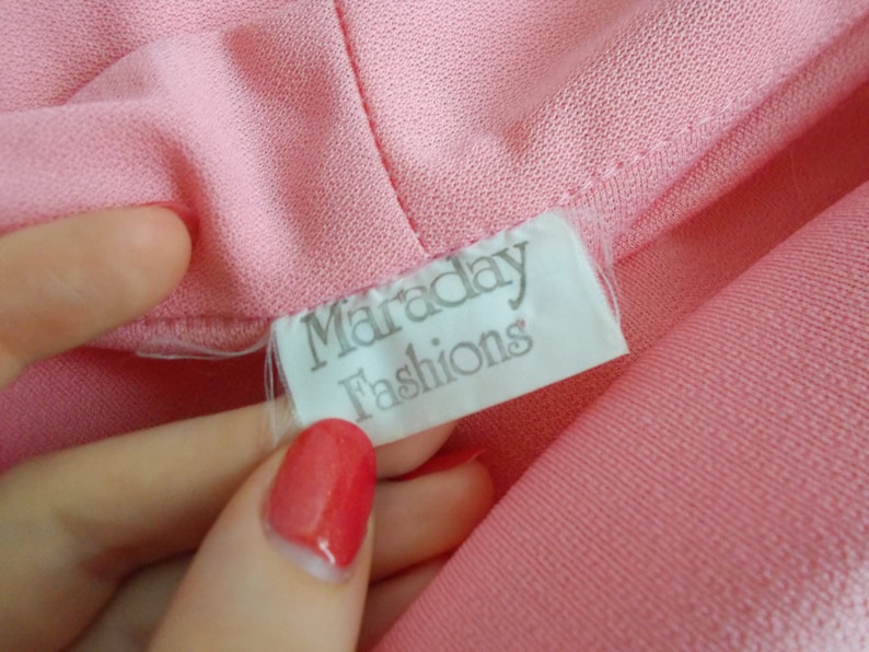 May include: A white tag with the text "Maraday Fashions" on a pink fabric background.