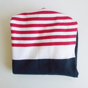 K&ouml;nnte beinhalten: Eine rot-wei&szlig; gestreifte Strickm&uuml;tze mit einem dunkelblauen Rand.