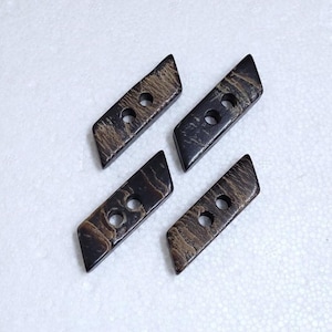 May include: Four brown and gold rectangular buttons with two holes each. The buttons have a marbled pattern.