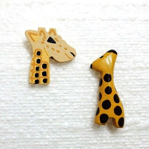 May include: Two wooden giraffe figurines, one with a long neck and the other with a short neck. Both giraffes are painted yellow with black spots.