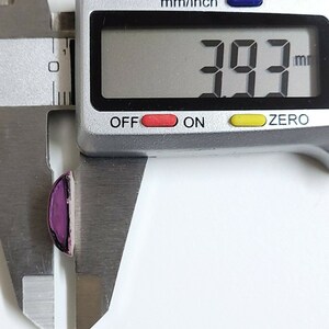 May include: A close-up of a digital caliper measuring a purple and silver object. The reading on the caliper is 39.3 mm.