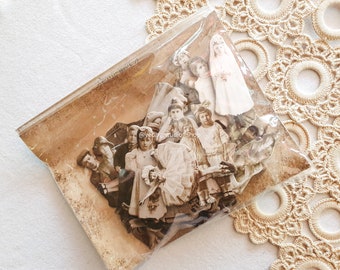 Könnte beinhalten: Eine durchsichtige Plastiktüte gefüllt mit Papierschnitten von Kindern im Vintage-Stil. Die Ausschnitte sind in verschiedenen Posen und auf braunem Hintergrund gedruckt. Die Tüte liegt auf einer gehäkelten Deckchen.