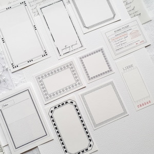 Op de afbeelding: Een set decoratieve zwart-witte frame stickers met verschillende ontwerpen. De stickers zijn op een witte achtergrond. Sommige stickers hebben tekst, waaronder "something special", "LIEBE" en "KOMBI-TICKET".