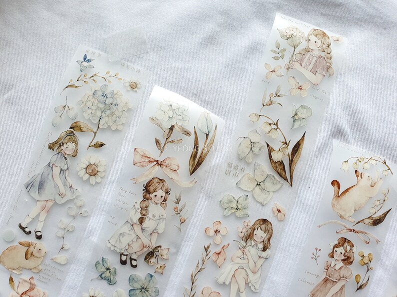 Peut inclure: Ruban adh&eacute;sif d&eacute;coratif avec des illustrations &agrave; l'aquarelle de filles, de fleurs et d'animaux. Le ruban comprend des images de marguerites, d'hortensias et de lapins. Les illustrations sont dans des couleurs pastel douces.