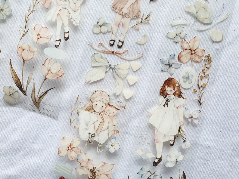 Peut inclure: Ruban adh&eacute;sif d&eacute;coratif avec des illustrations &agrave; l'aquarelle de filles, de fleurs et de n&oelig;uds dans des tons pastel. Le ruban comprend des fragments de texte et est id&eacute;al pour le scrapbooking et les projets de bricolage.