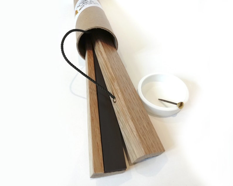 K&ouml;nnte beinhalten: Ein Satz magnetischer Posteraufh&auml;nger aus Holz in einer braunen Papprolle. Die Aufh&auml;nger sind hellbraun mit einem schwarzen Magnetstreifen. Eine kleine wei&szlig;e Schale und eine Messingstiftspitze sind ebenfalls vorhanden.