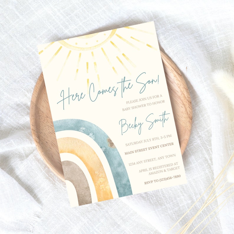 May include: A baby shower invitation featuring a watercolour rainbow and sun design. The text reads "Here Comes the Son!" and includes details about the event, including the date, time, location, and RSVP information.