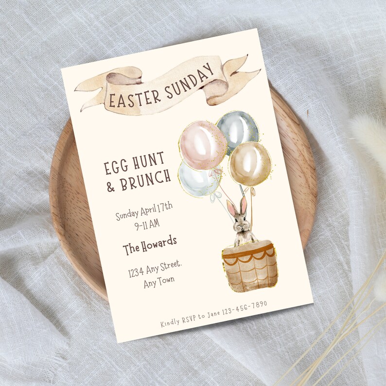 May include: An invitation to an Easter Sunday egg hunt and brunch. The invitation features a watercolor illustration of a bunny in a hot air balloon with pastel colored balloons. The text reads "Easter Sunday", "Egg Hunt & Brunch", "Sunday April 17th 9-11 AM", "The Howards", "1234 Any Street. Any Town", and "Kindly RSVP to Jane 123-456-7890".