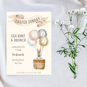 May include: An invitation to an Easter Sunday egg hunt and brunch. The invitation features a watercolor illustration of a bunny in a hot air balloon with pastel colored balloons. The text reads "Easter Sunday", "Egg Hunt & Brunch", "Sunday April 17th", "9-11 AM", "The Howards", "1234 Any Street", "Any Town", and "Kindly RSVP to Jane 123-456-7890".